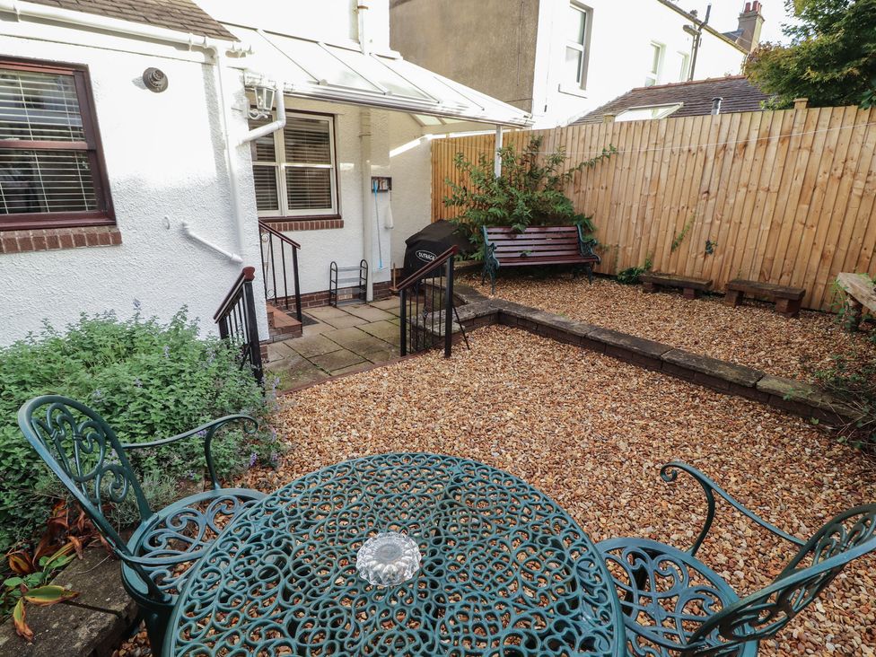 A garden with a table and chairs at Riverside Cottage in Cockermouth