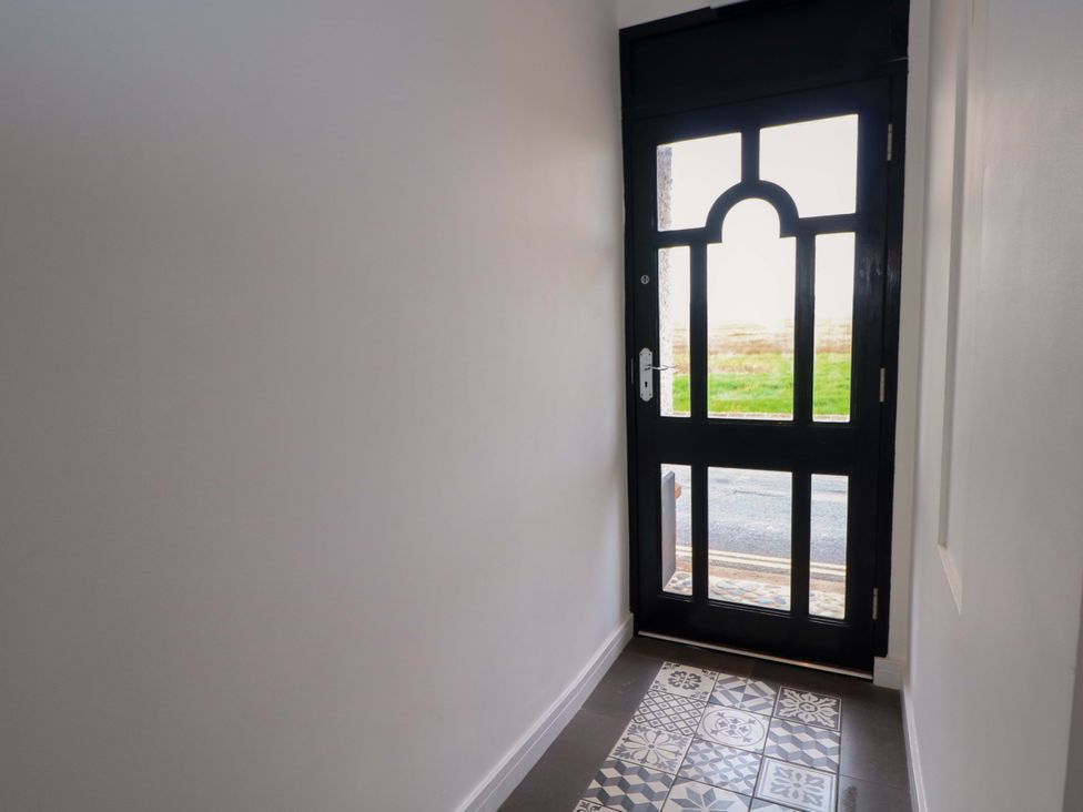 A hallway with a door and patterned floor at Broad Beams Parkgate near Neston