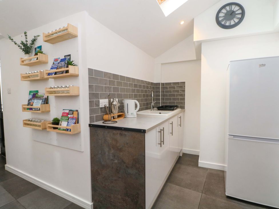 A kitchen with a sink and refrigerator at Broad Beams Parkgate near Neston