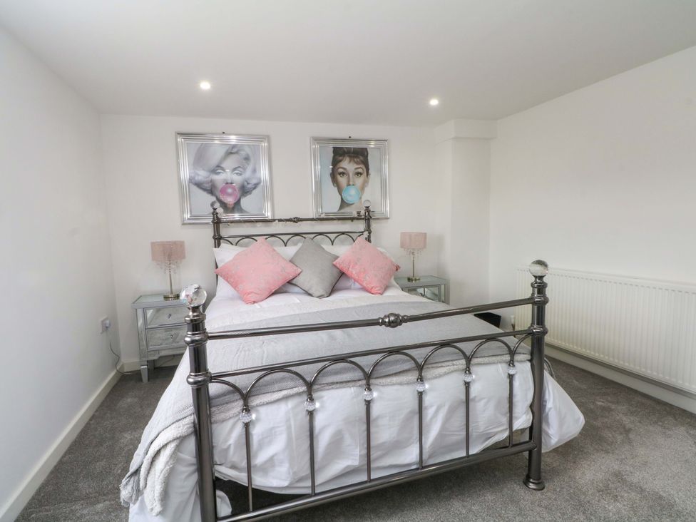 A bedroom with a bed and wall art at Broad Beams Parkgate near Neston