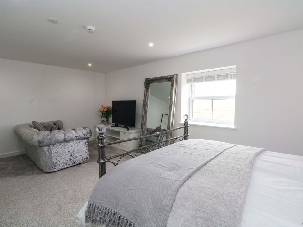 A bedroom with a sofa and television at Broad Beams Parkgate near Neston