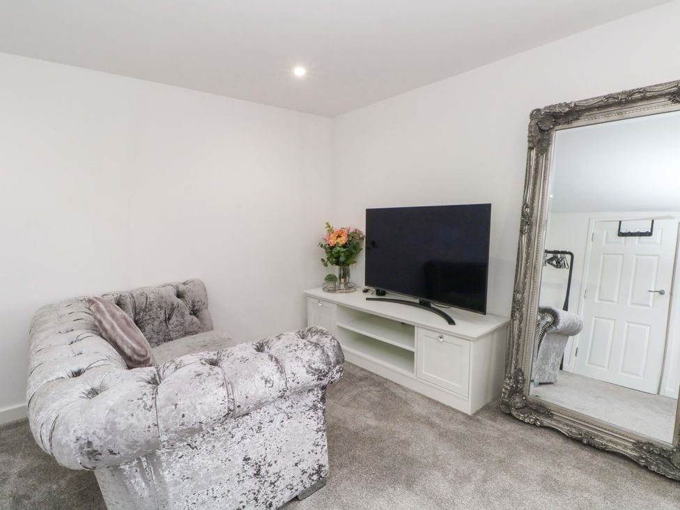 A living room with a sofa and television at Broad Beams in Parkgate near Neston
