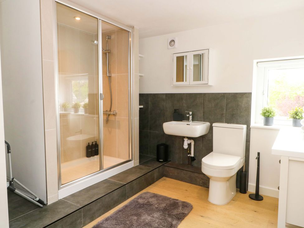 A bathroom with a shower, toilet, and sink at Broad Beams in Parkgate near Neston