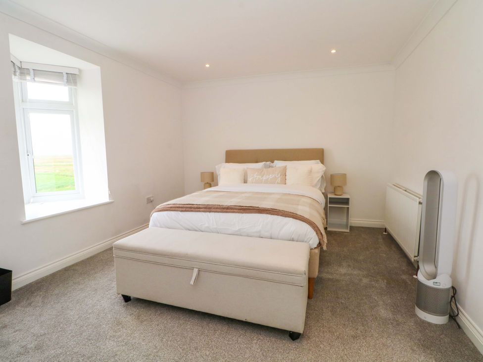 A bedroom with a bed and bedside tables at Broad Beams Parkgate near Neston