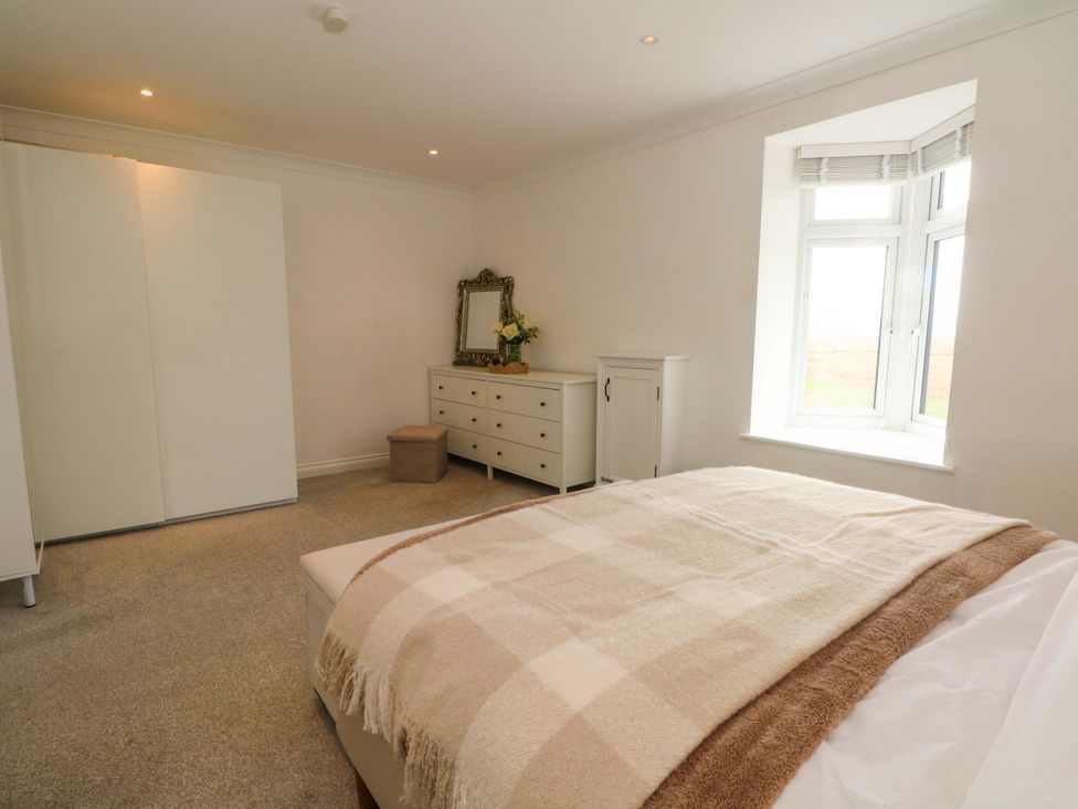 A bedroom with a bed and furniture at Broad Beams Parkgate near Neston
