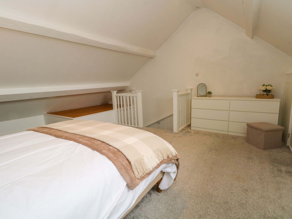 A bedroom with a bed and a dressing table at Broad Beams Parkgate near Neston