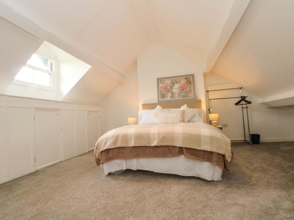 A bedroom with a bed and a clothing rack at Broad Beams in Parkgate near Neston