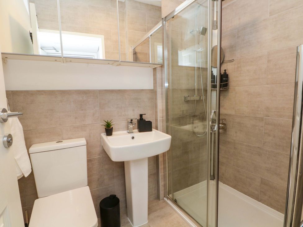 A bathroom with a shower, toilet, and sink at Broad Beams in Parkgate near Neston