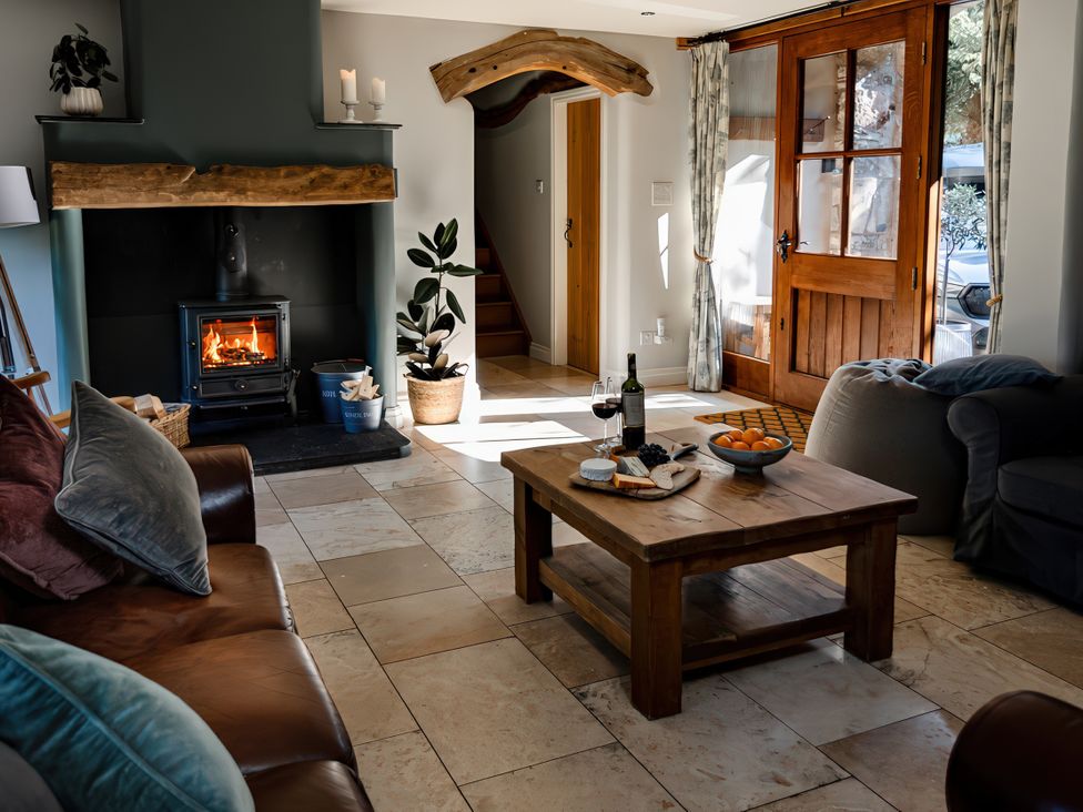 A living room with a fireplace and a coffee table at Carrholme Cottage in Settle