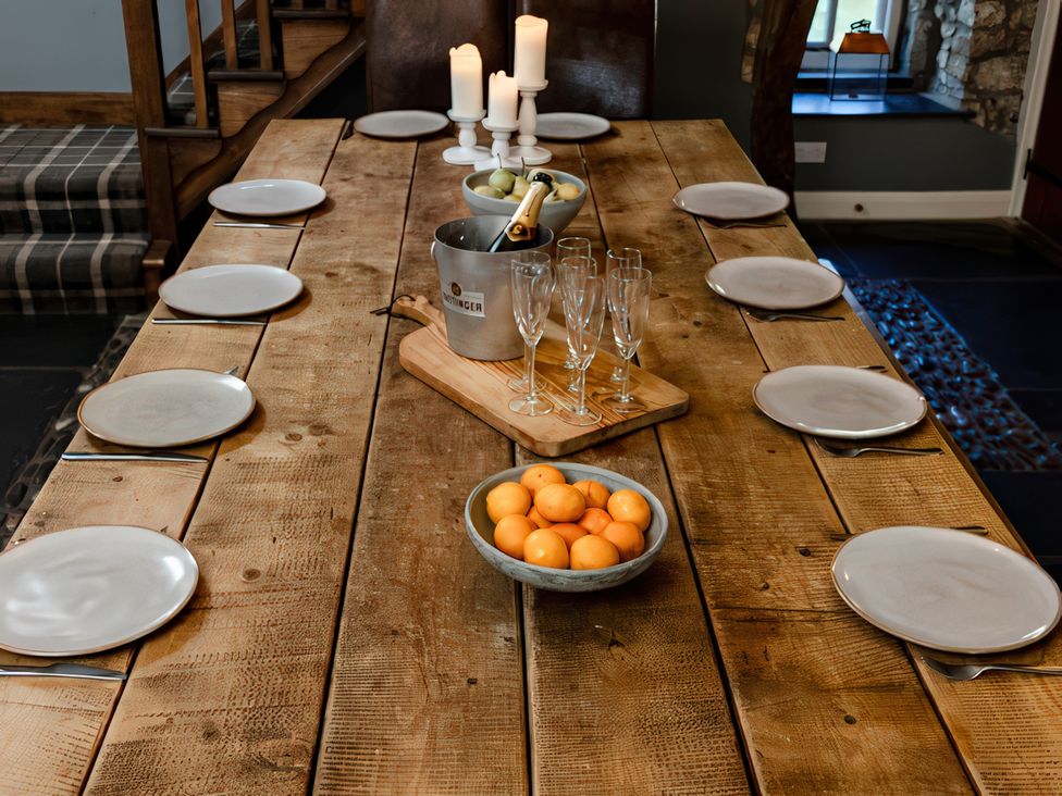 A dining table with plates and candles at Carrholme Cottage in Settle