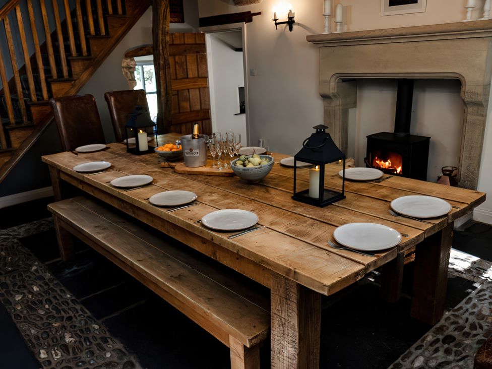 A dining room with a wooden table and plates at Carrholme Cottage Settle