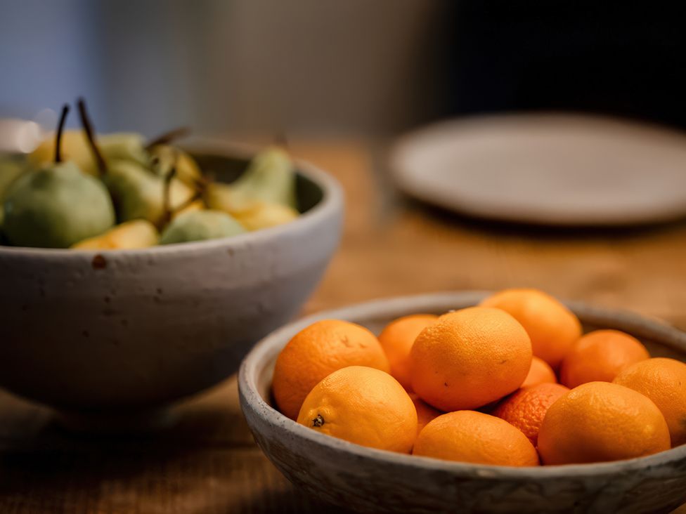 A bowl of oranges and a bowl of pears on a table at Carrholme Cottage Settle