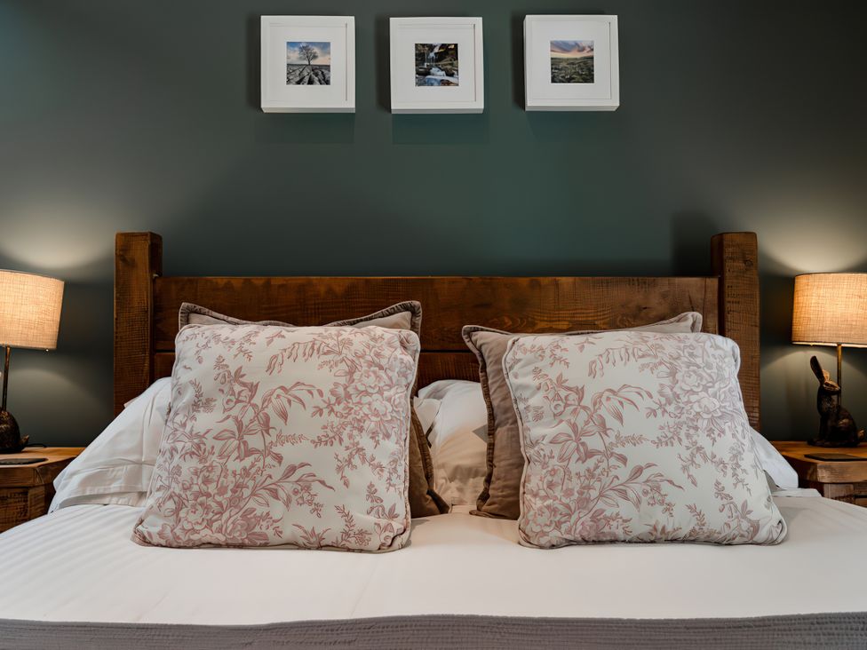 A bedroom with a bed and pillows at Carrholme Cottage Settle