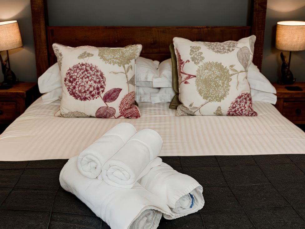 A bedroom with pillows and towels on a bed at Carrholme Cottage in Settle
