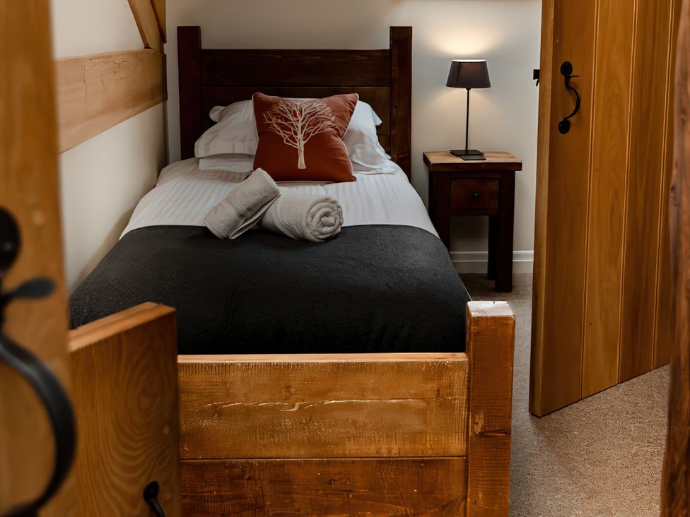 A bedroom with a single bed and bedside table at Carrholme Cottage Settle