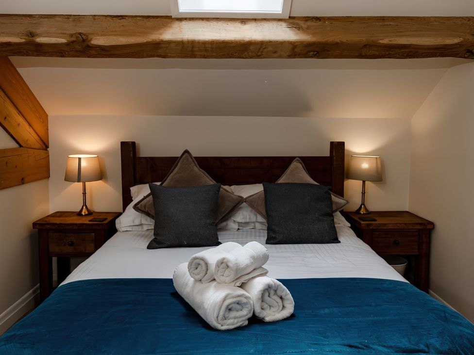 A bedroom with a bed and bedside tables at Carrholme Cottage in Settle