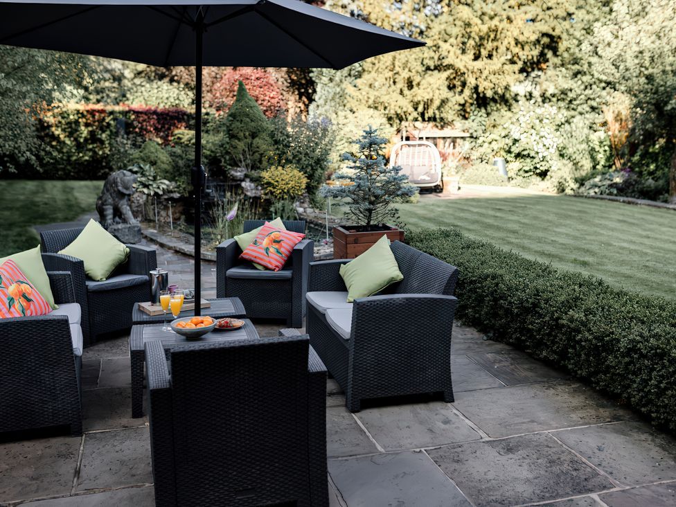 A garden seating area with chairs and a table at Carrholme Cottage Settle