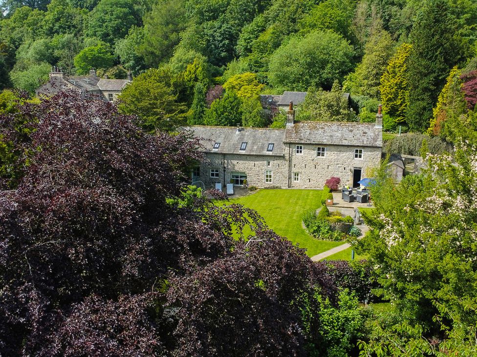 A stone house with a garden and furniture at Carrholme Cottage Settle