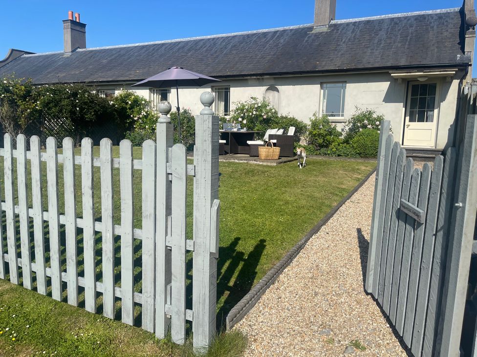 A garden with a fence and patio furniture at Mappowder Cottage Buckland Newton near Dorchester