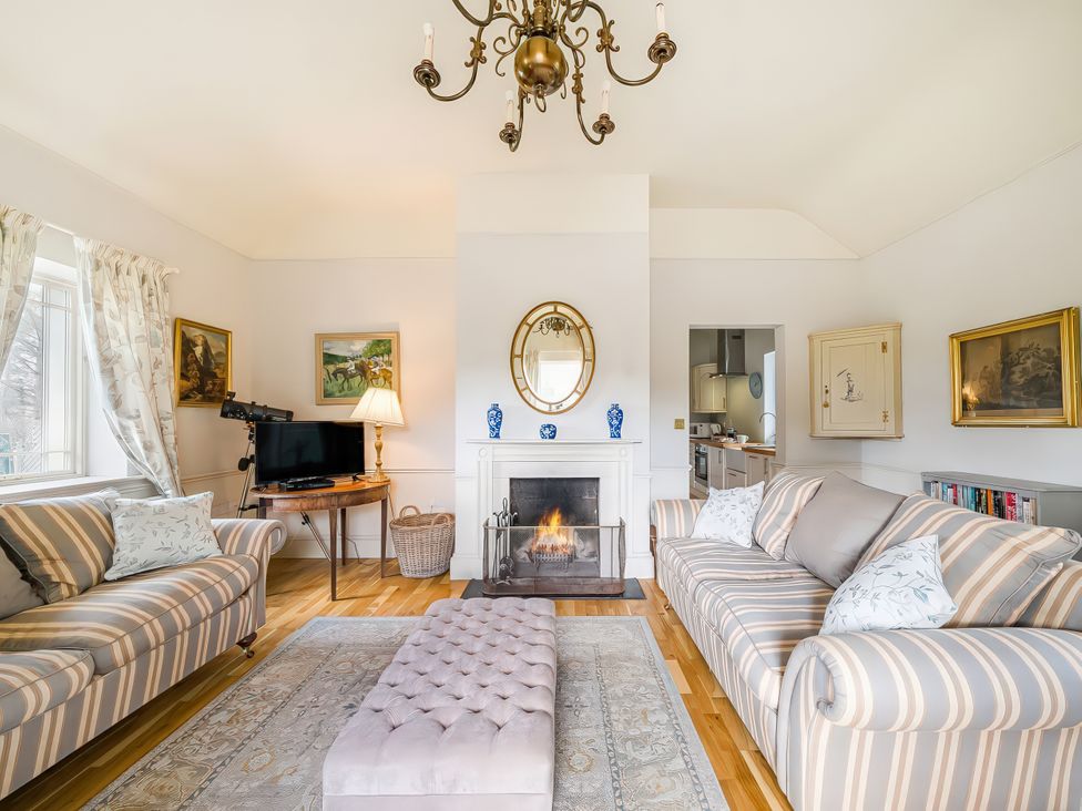 A living room with a fireplace and seating area at Mappowder Cottage in Buckland Newton near Dorchester