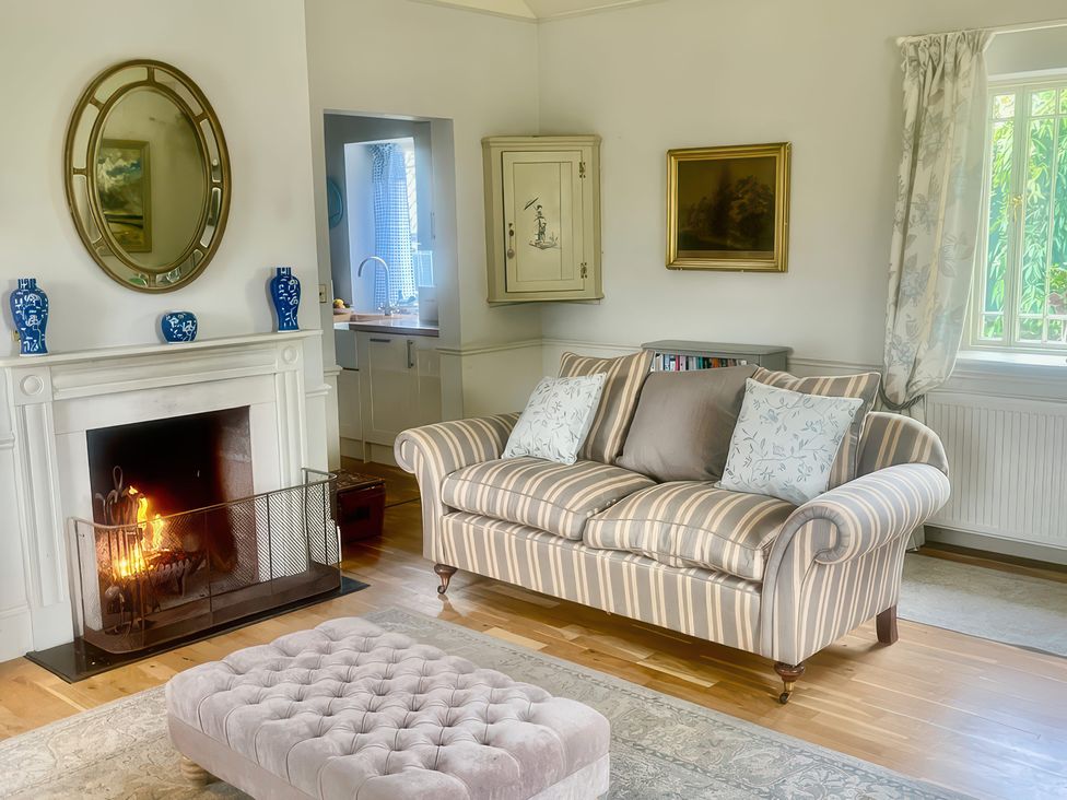 A living room with a sofa and fireplace at Mappowder Cottage in Buckland Newton near Dorchester
