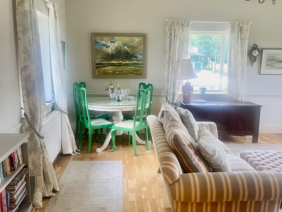 A living room with a dining table and chairs at Mappowder Cottage in Buckland Newton near Dorchester
