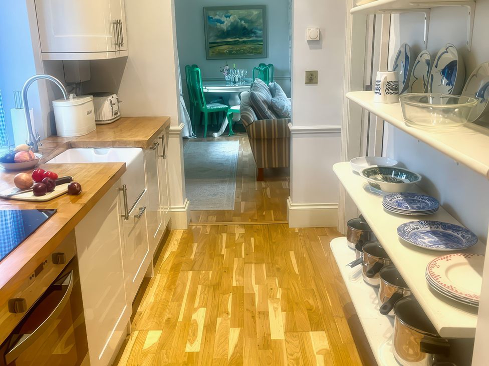 A kitchen with a sink and wooden cabinets at Mappowder Cottage in Buckland Newton near Dorchester