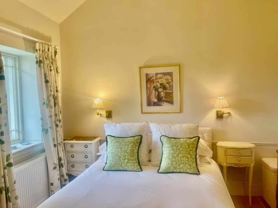 A bedroom with a bed and nightstand at Mappowder Cottage Buckland Newton near Dorchester