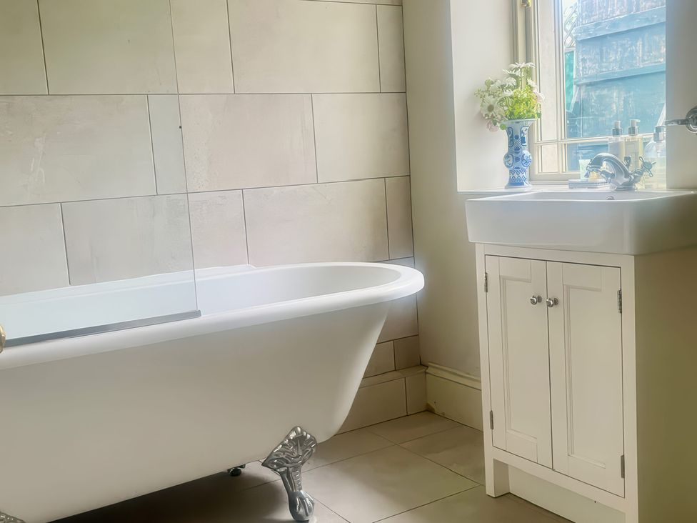 A bathroom with a bathtub and sink at Mappowder Cottage in Buckland Newton near Dorchester