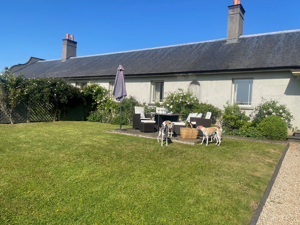 A garden with dogs near furniture at Mappowder Cottage in Buckland Newton near Dorchester