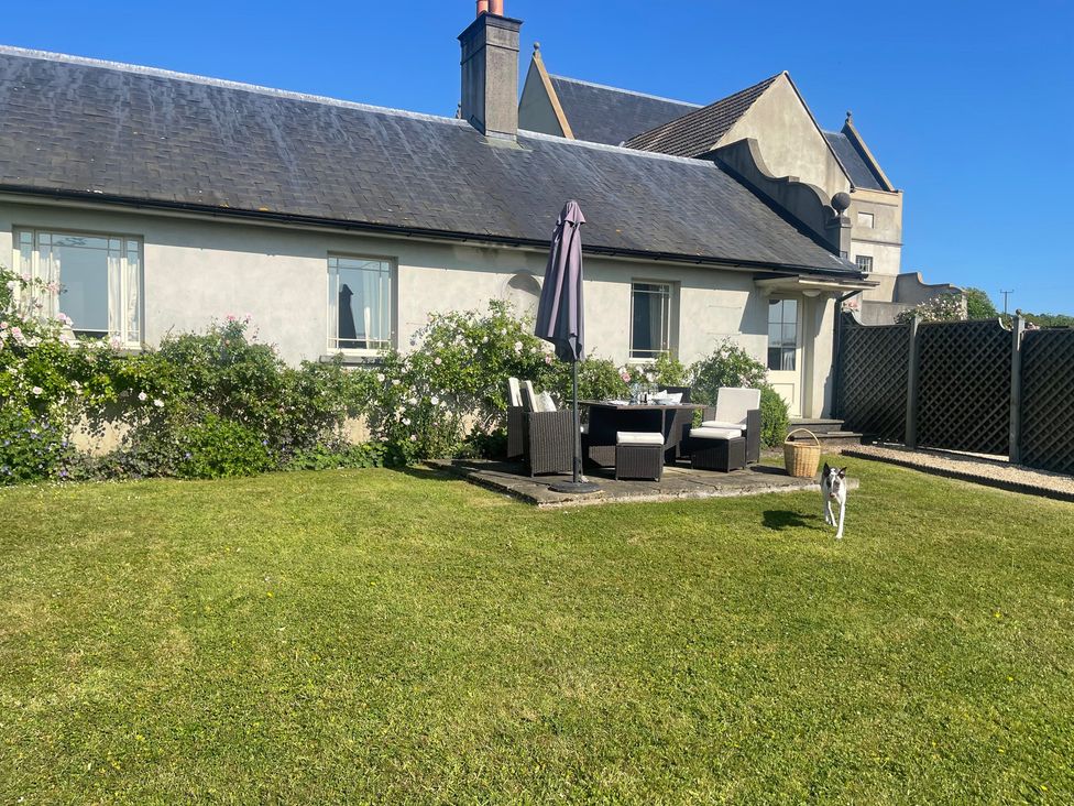 An outdoor area with furniture and a dog at Mappowder Cottage Buckland Newton near Dorchester