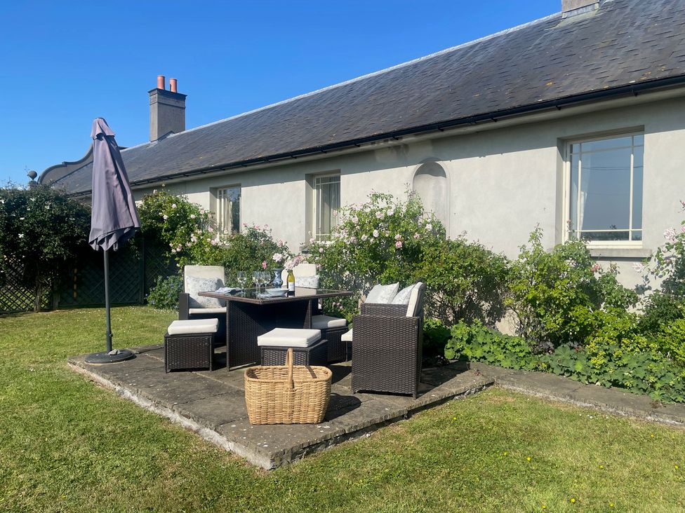 A garden with a table and chairs at Mappowder Cottage, Buckland Newton near Dorchester