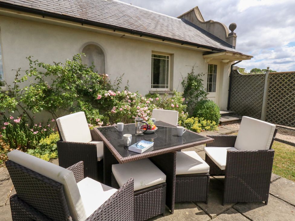A garden with a seating area and flowering plants at Mappowder Cottage Buckland Newton near Dorchester