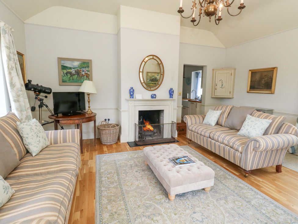 A living room with a fireplace and furniture at Mappowder Cottage in Buckland Newton near Dorchester