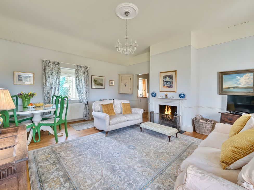 A living room with a fireplace and dining area at Maple Cottage Buckland Newton near Dorchester