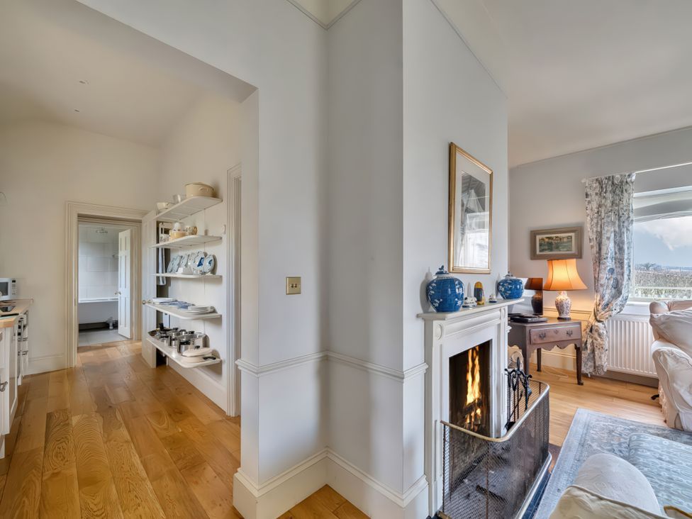 A living room with a fireplace and shelving at Maple Cottage Buckland Newton near Dorchester