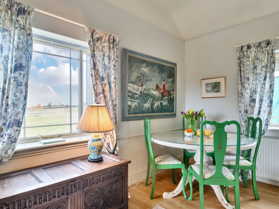 A dining room with a green table and chairs at Maple Cottage Buckland Newton near Dorchester