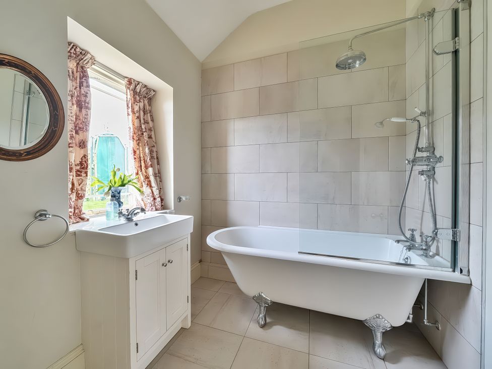 A bathroom with a bathtub and sink at Maple Cottage Buckland Newton near Dorchester