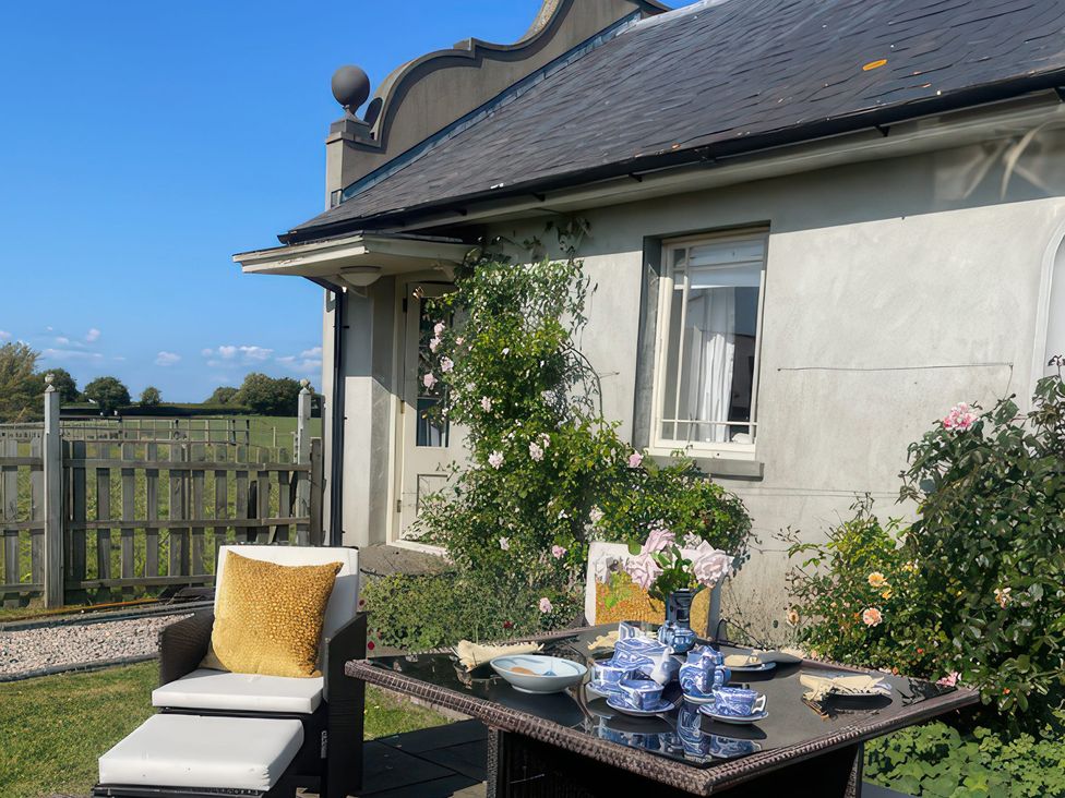 An outdoor seating area with a table set for tea at Maple Cottage in Buckland Newton near Dorchester