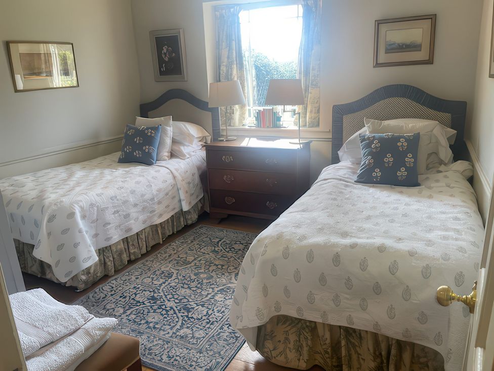 A bedroom with two beds and a window at Maple Cottage Buckland Newton near Dorchester