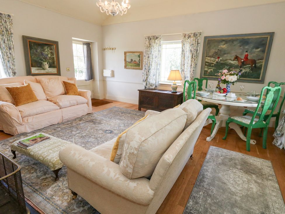A living room with a sofa and dining table at Maple Cottage in Buckland Newton near Dorchester