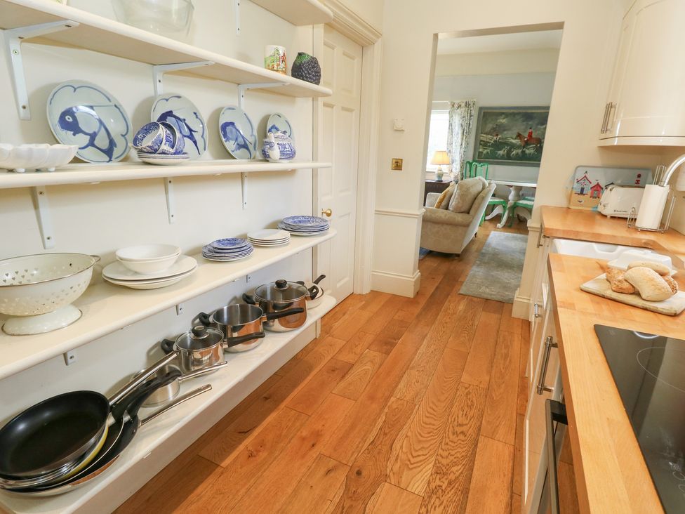 A kitchen with shelves containing dishes and pans at Maple Cottage in Buckland Newton near Dorchester