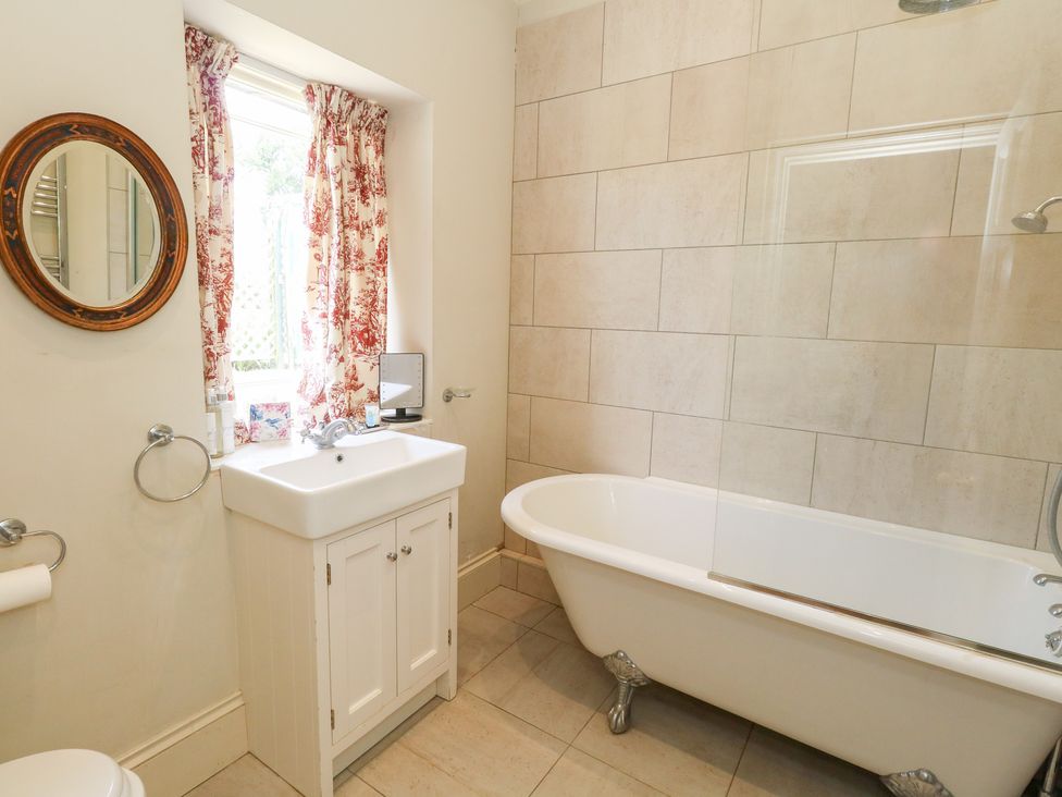 A bathroom with a bathtub and sink at Maple Cottage Buckland Newton near Dorchester