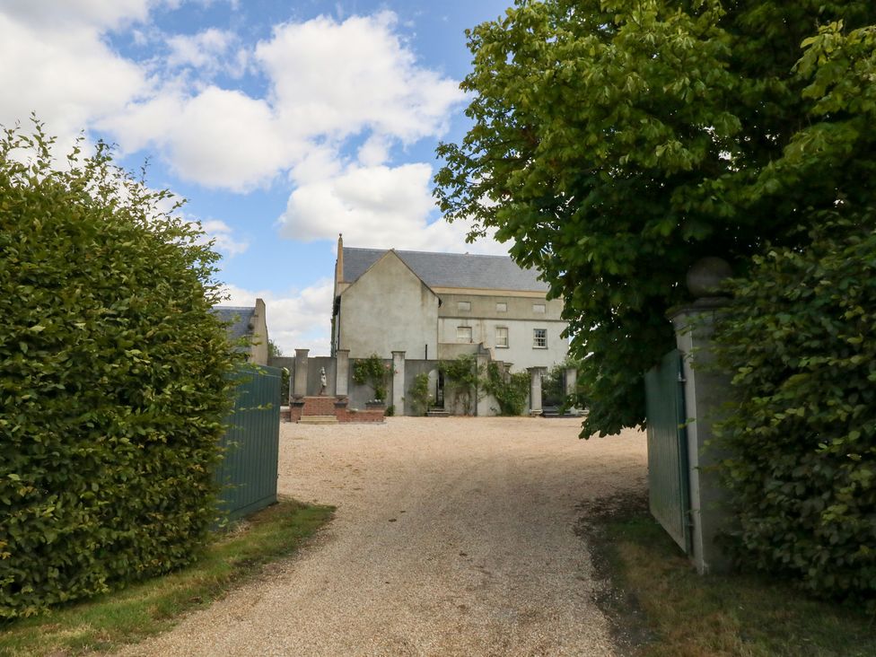 A house with a gravel driveway and greenery at Maple Cottage Buckland Newton near Dorchester