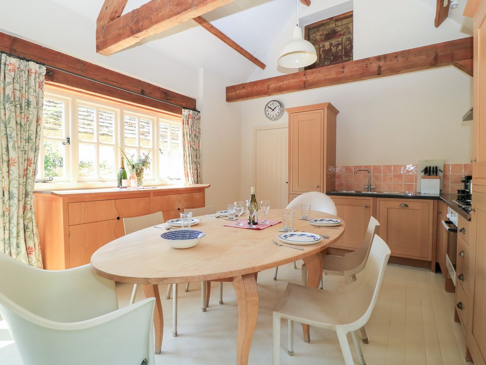A dining room with a table and chairs at Upper Mill Barn in Coln St Aldwyns, near Bibury