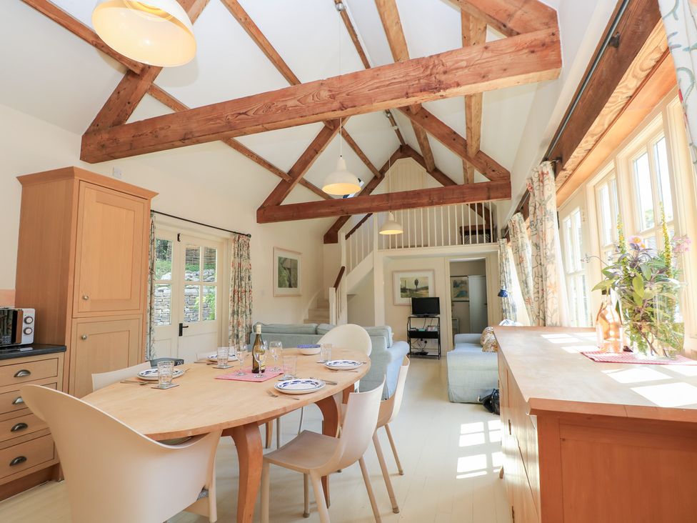 A dining room with a table and chairs at Upper Mill Barn, Coln St Aldwyns, near Bibury