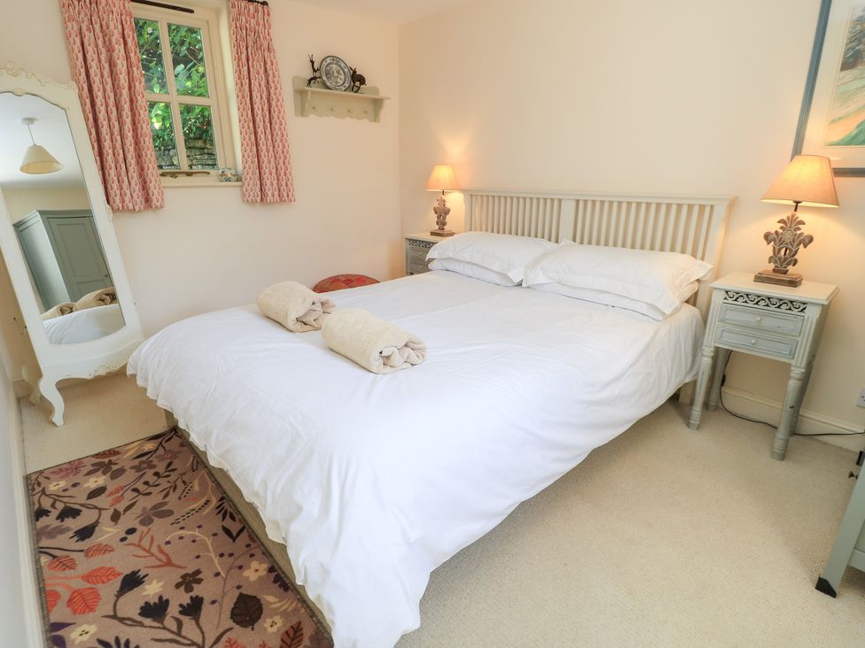 A bedroom with a bed and bedside tables at Upper Mill Barn, Coln St Aldwyns, near Bibury