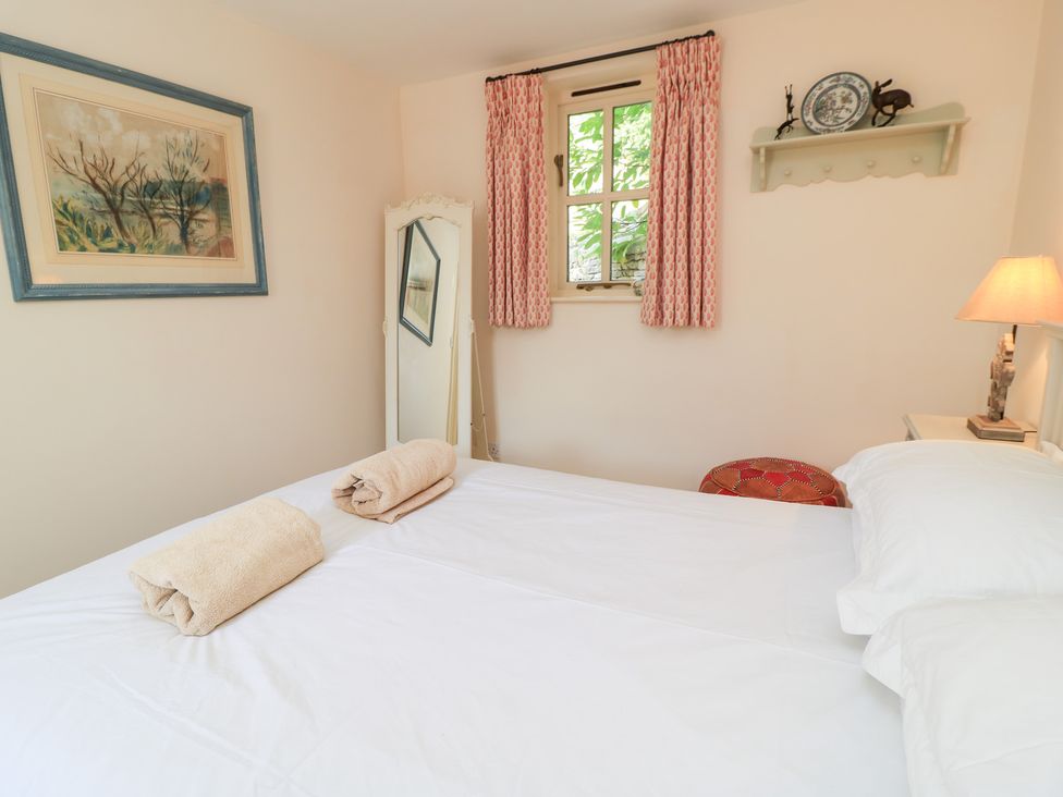 A bedroom with a bed and towels on it at Upper Mill Barn, Coln St Aldwyns, near Bibury