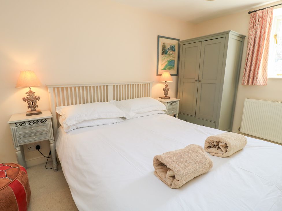 A bedroom with a bed and lamps at Upper Mill Barn, Coln St Aldwyns, near Bibury