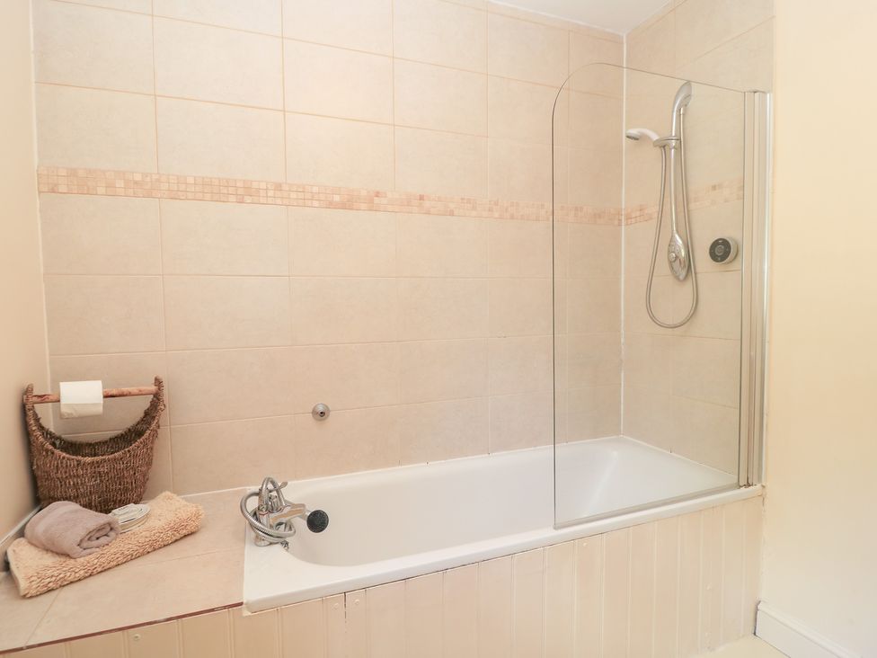 A bathroom with a bathtub and shower at Upper Mill Barn in Coln St Aldwyns, near Bibury